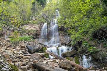 Fototapeta na wymiar Beautiful mountain waterfall in the forest in spring. Waterfall in the forest. Beautiful nature and relaxation.