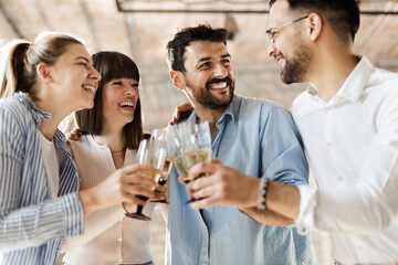Group of happy business people toasting with wine at office party