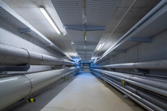 Empty underground tunnel with plumbing pipes