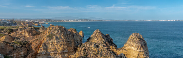 Ponta da Piedade (point of mercy) a headland with dramatic yellow-golden cliff-like rock formations, arches and grottos along the coastline of the town of Lagos, Algarve, Portugal