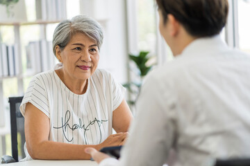 Asian seniors who are healthy, in a good mood, smiling, talking with financial or life insurance...