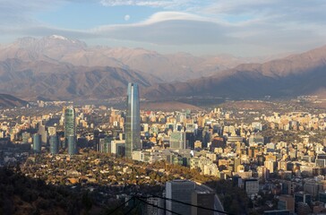 Santiago Chile Aerial Panorama View Cerro Cristobal Hill Famous Costanera Tower City Skyline. Full Moon Rising over Distant Andes Mountains Background
