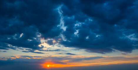 Naklejka na ściany i meble sunset on dramatic cloudy sky background