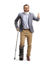 Bearded man with a cervical collar and orthopedic boot gesturing thumbs up