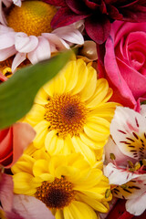 Un ramo de flores con una flor amarilla en el medio