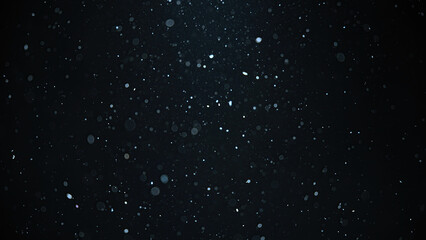 White snow falling on an isolated black background, bokeh of flying snowflakes, dust particles or powder in the air. 