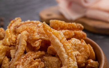Crispy Pork Belly Chicharron (torresmo)  is a popular dish in Spain and Latin America. Bowl of Fried Pork Skins on dark background