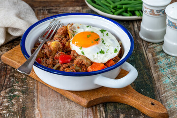 Corned beef hash with fried egg and green beans