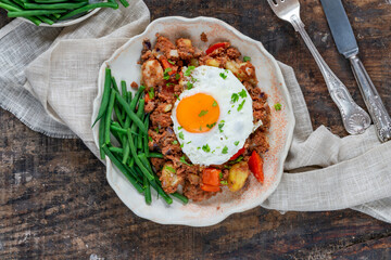 Corned beef hash with fried egg and green beans