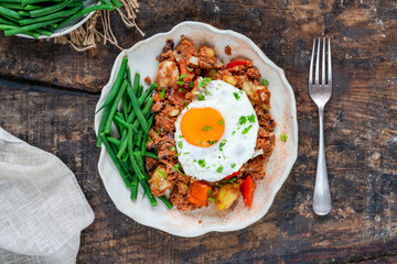 Corned beef hash with fried egg and green beans