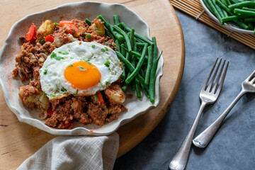Corned beef hash with fried egg and green beans