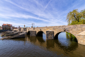 Fototapeta premium Historic stone bridge over river Otava in medieval town Pisek (Southern Bohemia) – the oldest preserved early Gothic bridge in the Czech Republic.