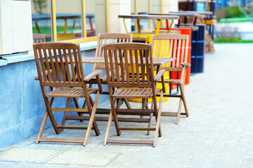 Folding wooden chairs and tables in an outdoor restaurant
