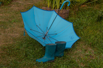Blue rubber boots blue umbrella lies awn.