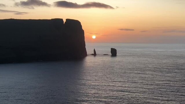 Sun setting over the sea and the sea stacks of Rising og Kellingin in the Faroe Islands, Denmark