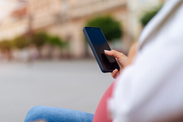 Pregnant woman using phone outdoors
