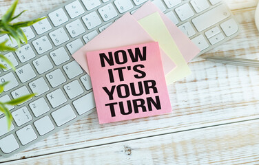 Now it's your turn text, inscription, phrase written in a notebook that lies on a dark table with a...