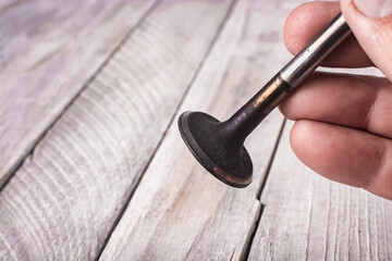 Old cylinder block valve in mechanic's hand.