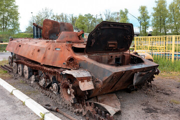 Fototapeta na wymiar Ukraine - A rusty armored personnel carrier is on display. Burnt Russian tanks in Ukraine. War in Ukraine
