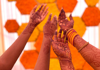 Close up of girls hand decorated with henna. Traditional Indian wedding celebration customs. Close up of many raised hands with Mehendi.