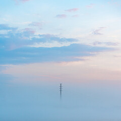 Fototapeta na wymiar Power Line in Fog at Sunrise