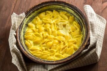 Pasta in a creamy sauce with cheese in a cast iron skillet.