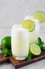 Brazilian Lemonade, Refreshing Creamy Lemonade or Limeade with Lime Slices and Mint on Grey Background