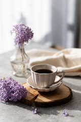 Creative composition with delicious hot coffee on table. Spring home cozy interior. A bouquet of flowers in a vase, a cup of espresso, decor on a coffee table. Mood.