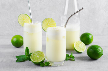 Brazilian Lemonade, Refreshing Creamy Lemonade or Limeade with Lime Slices and Mint on Grey Background