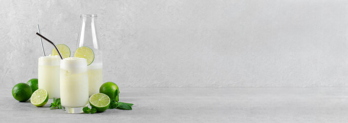 Brazilian Lemonade, Refreshing Creamy Lemonade or Limeade with Lime Slices and Mint on Grey Background