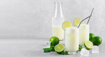 Brazilian Lemonade, Refreshing Creamy Lemonade or Limeade with Lime Slices and Mint on Grey Background