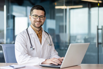 Portrait of a young intern specialist doctor sitting in the office at the table, studying, working...