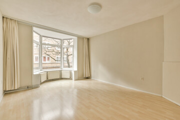 Fototapeta premium an empty living room with wood flooring and large windows looking out onto the street in front of the house