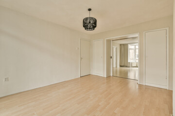 an empty room with white walls and wood flooring in the center of the room there is a chandel on the wall