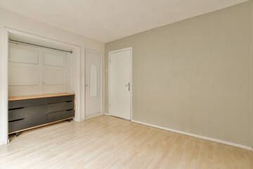 an empty room with white walls and wood flooring on the right, there is a large mirror in the corner