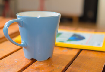 coffee cup on the table with paper - obrazy, fototapety, plakaty