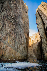 Rocky sea cliff with water passage