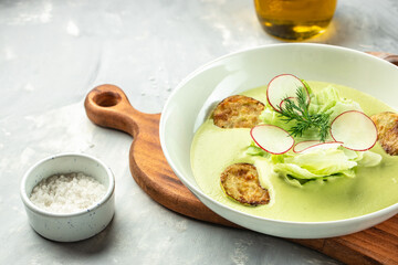 Green vegetable cream soup in a white bowl. Vegan soup puree of green vegetables. place for text, top view