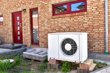 Luftwärmepumpe, Klimaanlage für Heizung und Warmwasser an einem verklinkerten Wohnhaus 