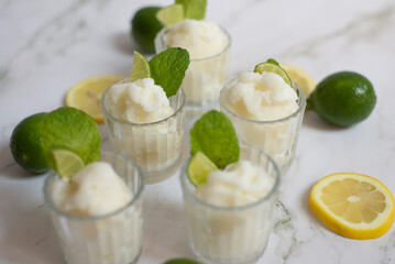 Copas con sorberte de limón con decoración de menta y rebanadas de lima