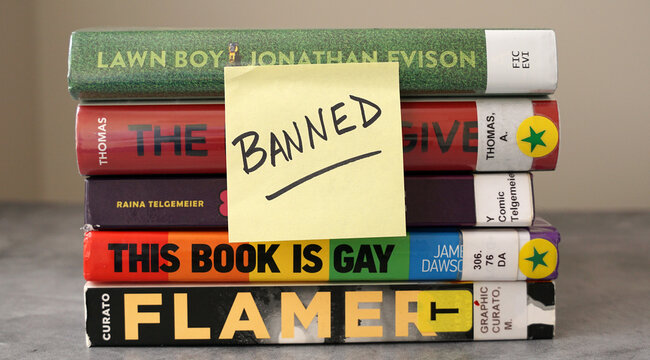 A Stack Of Books Found On Frequently Banned Book Lists With A Sticky Note Saying 