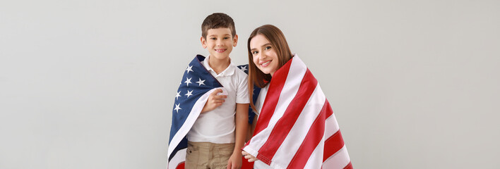 Woman and her son with USA flag on light background