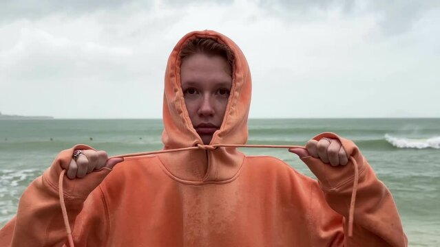 Portrait of unhappy depressed frozen trembling girl, young shivering from cold sad upset woman on the sea beach, bad weather on summer vacation 
