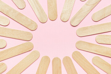 Frame made of ice cream sticks on pink background