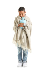 Ill African-American boy with hot water bottle on white background