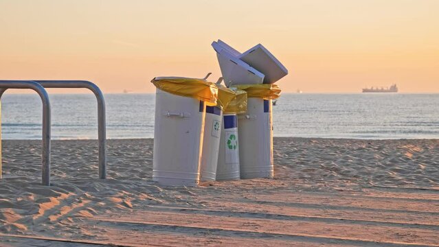 Metal Dumpster Bin Full of Garbage Waste after All Night Party on Beach