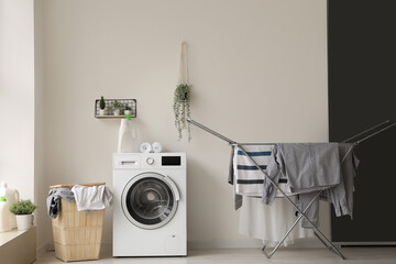 Interior of laundry room with washing machine, basket and dryer