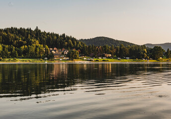 Malowniczy widok na miejscowość Zawóz, rozpościerający się z lśniących wod Jeziora Solińskiego. Miejsce, gdzie natura i człowiek żyją w harmonii.