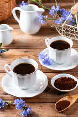 Medicinal plant chicory. The roots of the plants are used as a substitute for coffee. Drink from chicory in a cup on the wooden table. Rustic style, selective focus