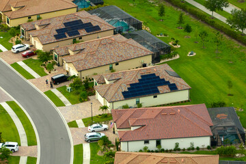 Aerial view of tightly located family houses with solar panels on roofs in Florida closed suburban...
